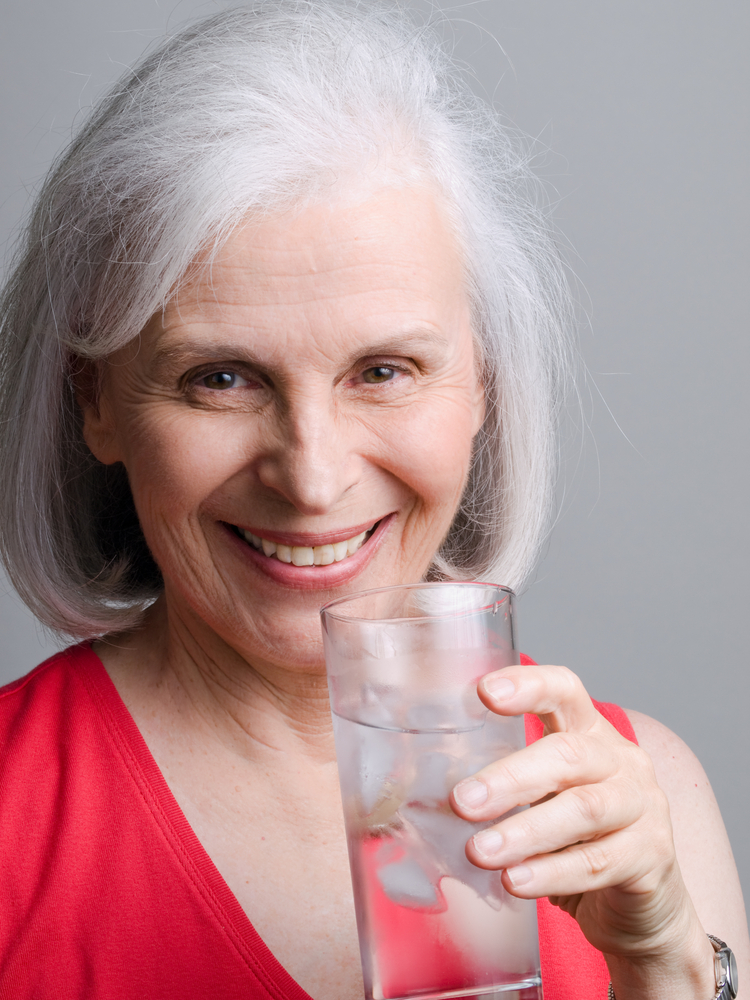 mature woman drinking a glass of water.jpg